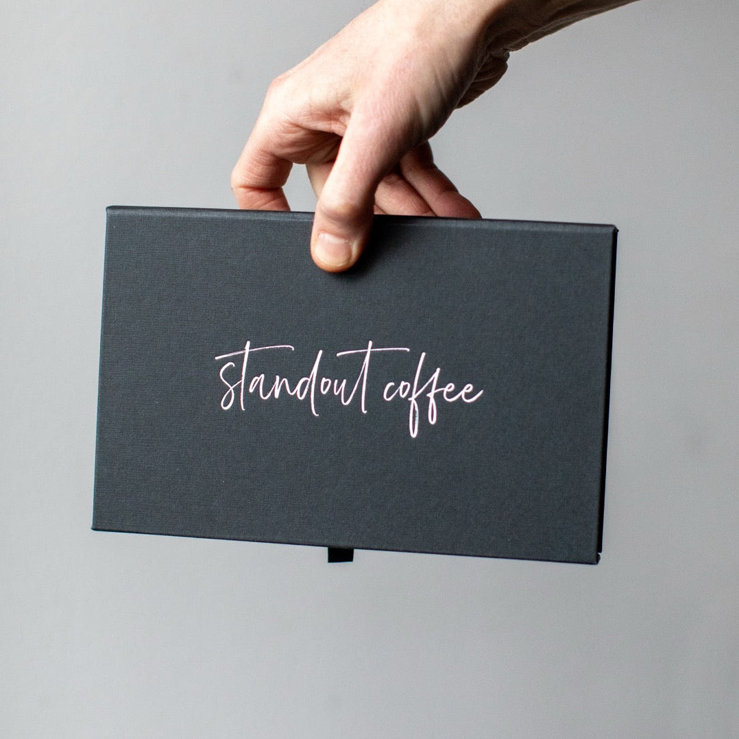 Hand holding a black box with &