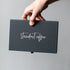 Hand holding a black box with &